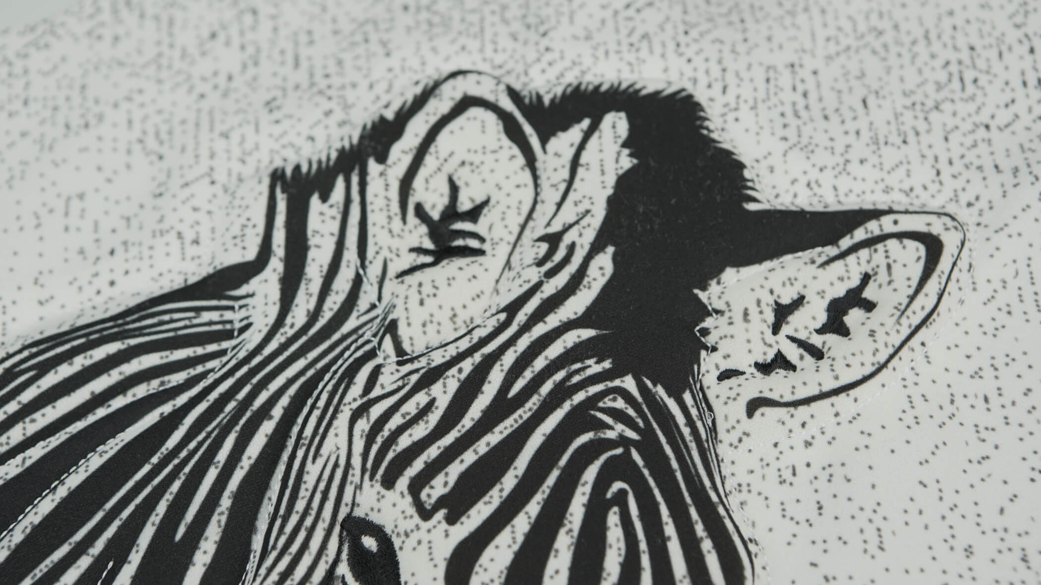 detalhe de bordado acolchoado em que é percetível a imagem de uma zebra