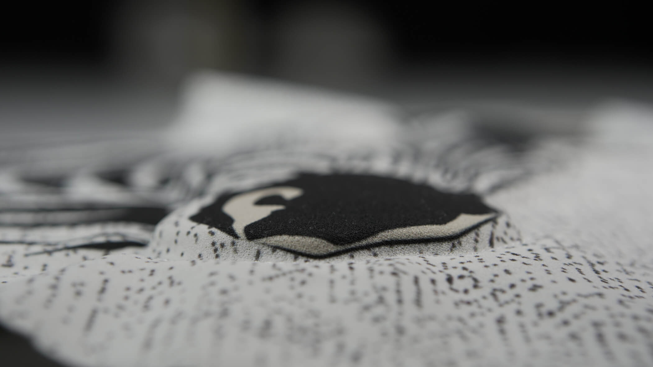 detalhe de bordado acolchoado em cores branca e preta desenvolvido pelo Grupo Bordados Oliveira