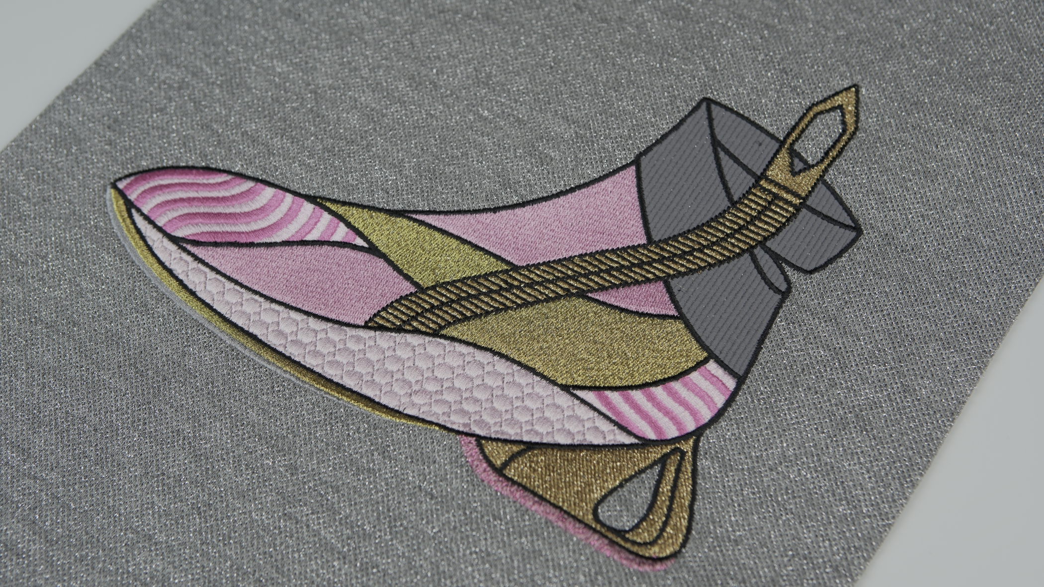 Desenho de uma bota em tons de rosa, dourado e cinza, utilizando a técnica de bordado matizado com efeitos