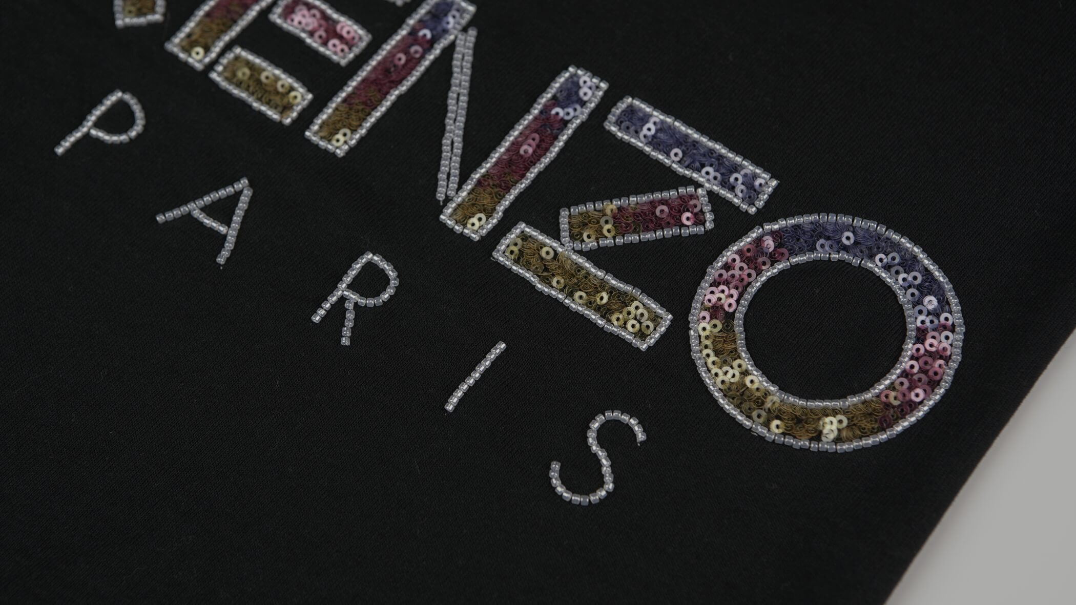 leem as letras ENZO e a palavra completa Paris num bordado em missangas sobre fundo preto criato pela bordados oliveira