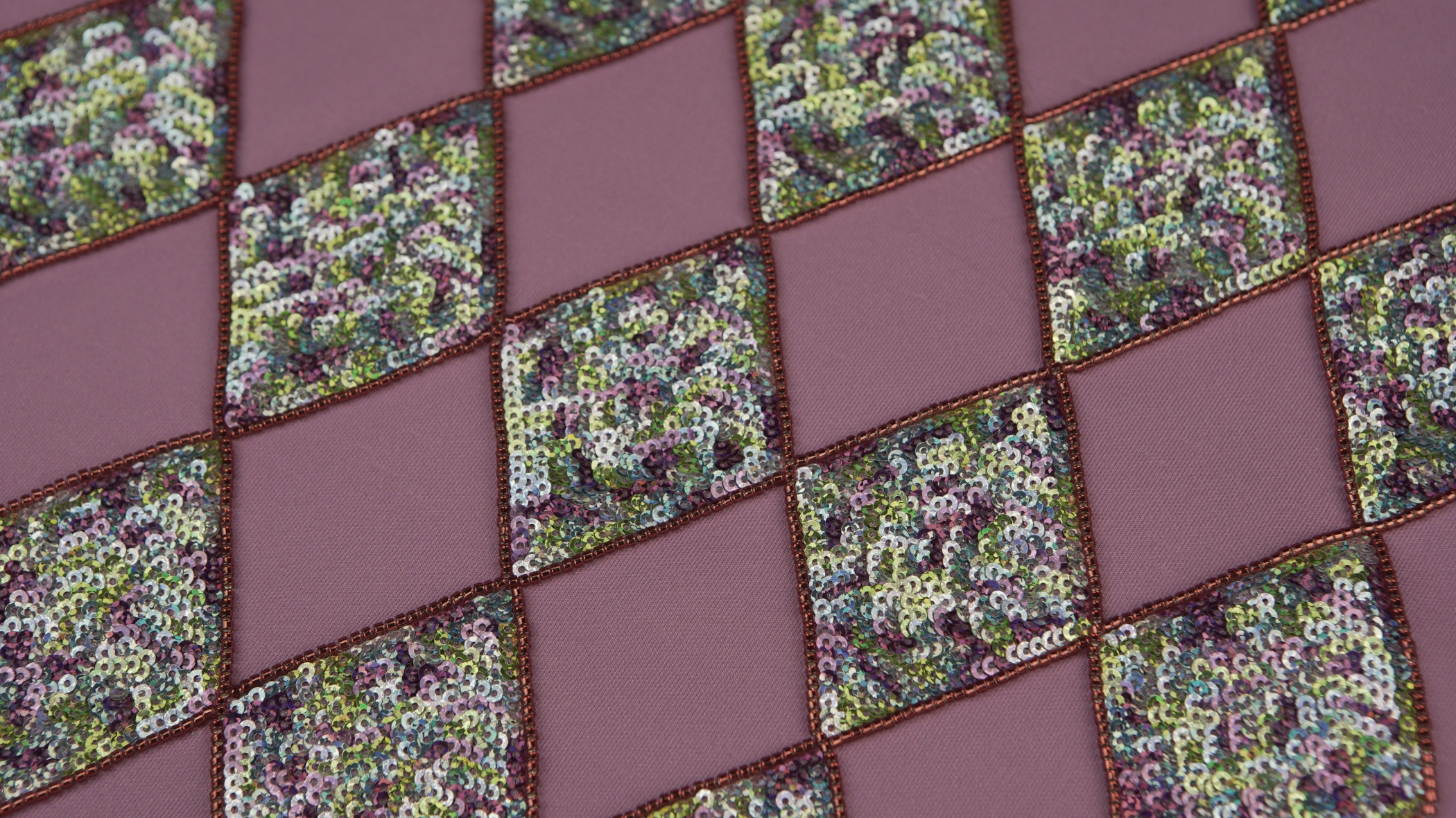 quadrados de lantejoulas de diversas cores misturadas, como por exemplo, azul, rosa e verde, com a técnica de Bordado em lantejoulas