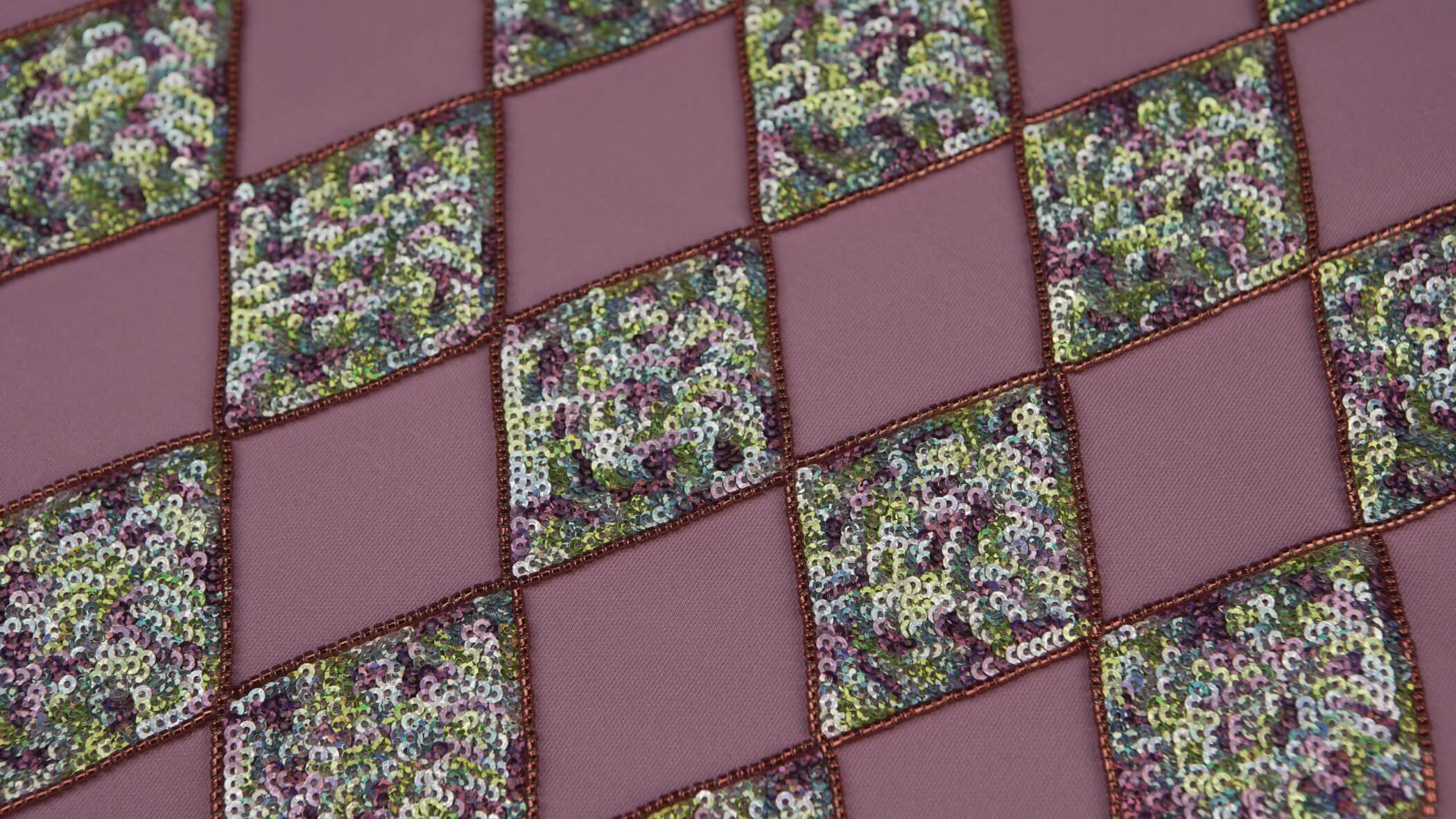 diversos quadrados de lantejoulas de várias cores misturadas, como por exemplo, azul, rosa e verde, com a técnica de Bordado em lantejoulas