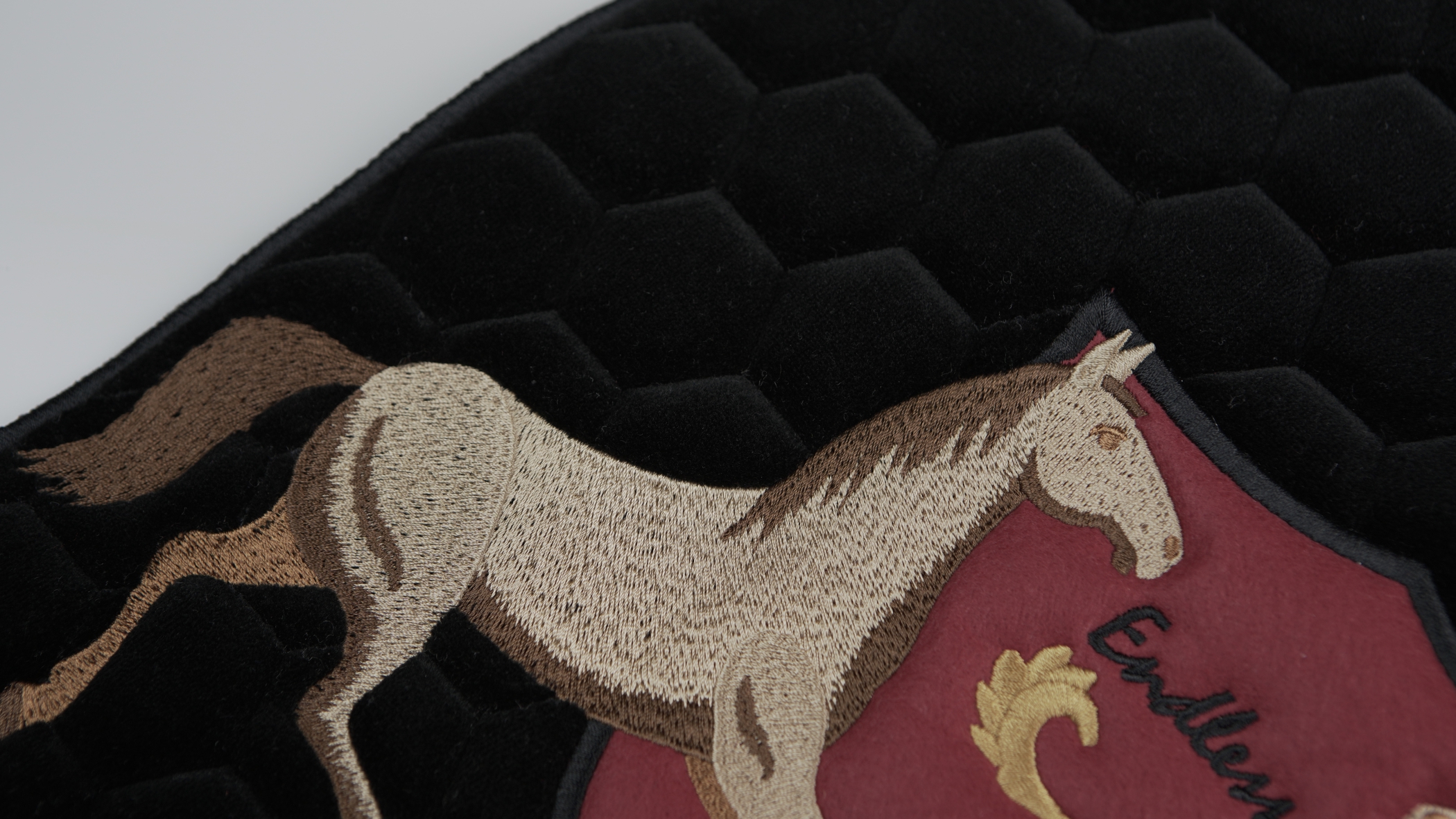 Pormenor de bordado normal com o desenho de um cavalo em tons de castanhos desenvolvido pela Bordados Oliveira