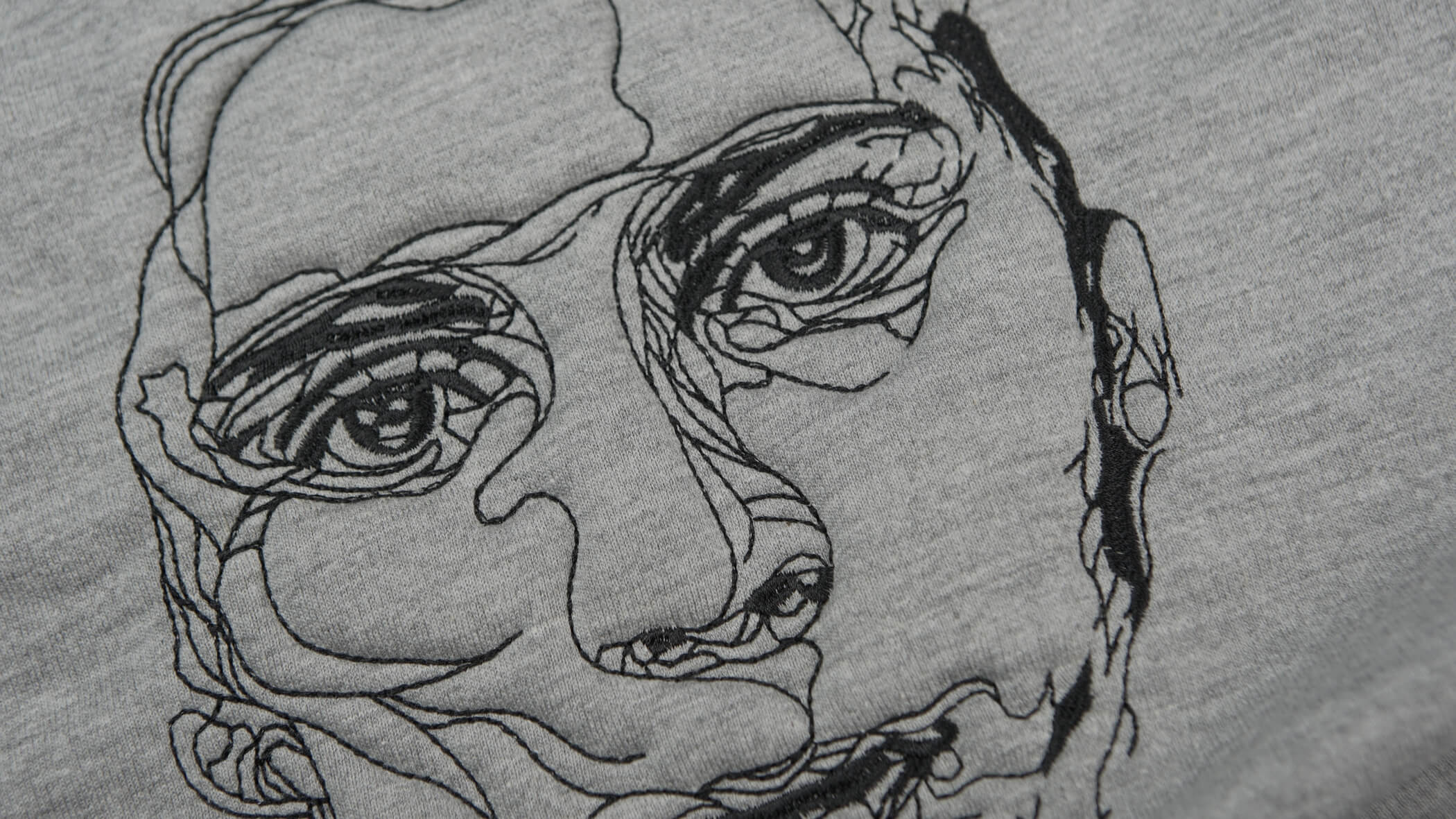 rosto de humano criado com técnicas de bordado normal com linhas pretas